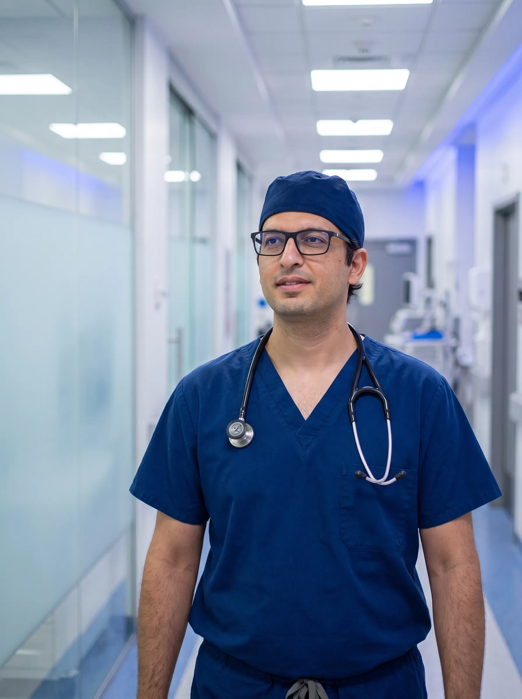 Dr Khan in surgical scrubs in a hospital corridor