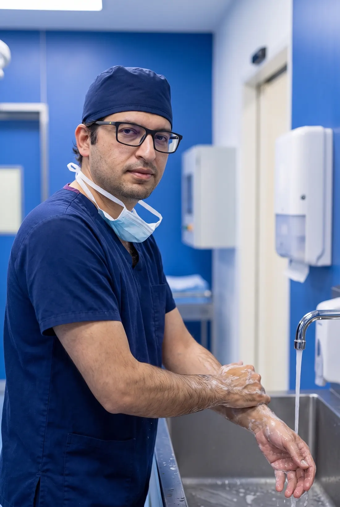 Dr Khan in surgical scrubs, scrubbing in before an operation